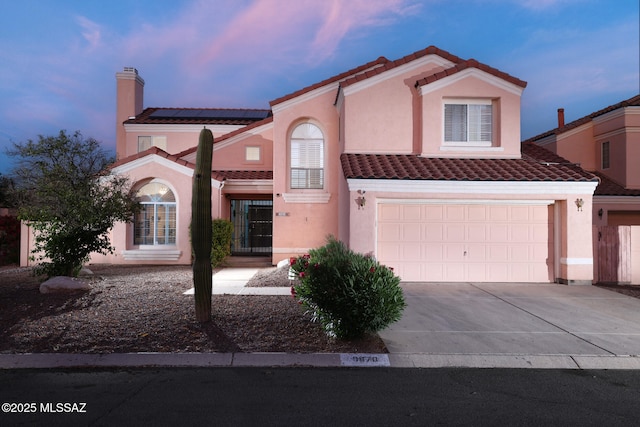 9870 N Meadow Flower Pl, Tucson, AZ 85742 - view of front of house featuring a tiled roof, solar panels, driveway, and stucco siding