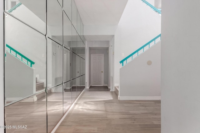 9870 N Meadow Flower Pl, Tucson, AZ 85742 - hallway with wood finished floors, baseboards, and a towering ceiling