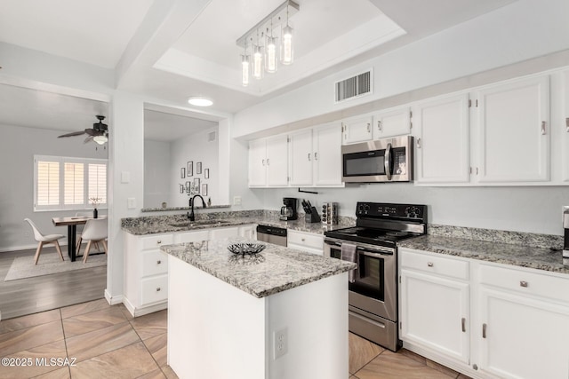 9870 N Meadow Flower Pl, Tucson, AZ 85742 - kitchen featuring stainless steel appliances, a sink, a center island, and white cabinets