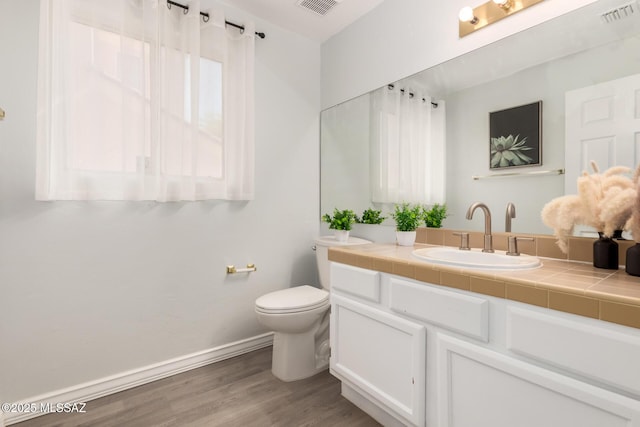 9870 N Meadow Flower Pl, Tucson, AZ 85742 - bathroom with toilet, wood finished floors, vanity, and baseboards