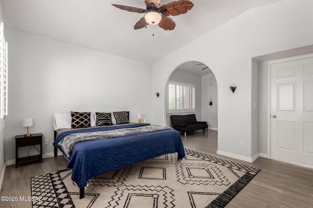 9870 N Meadow Flower Pl, Tucson, AZ 85742 - bedroom featuring arched walkways, vaulted ceiling, wood finished floors, and baseboards