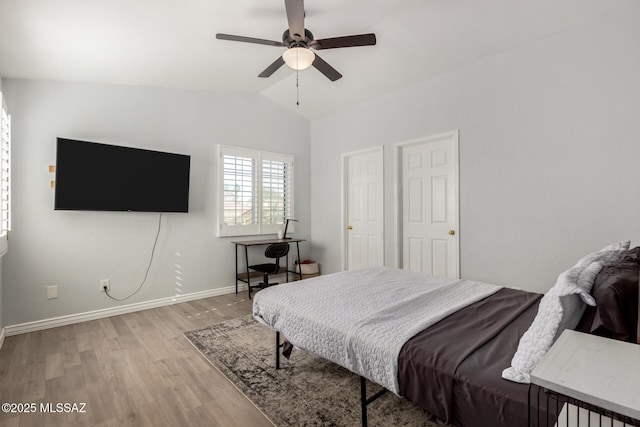 9870 N Meadow Flower Pl, Tucson, AZ 85742 - bedroom featuring light wood-style floors, vaulted ceiling, baseboards, and ceiling fan