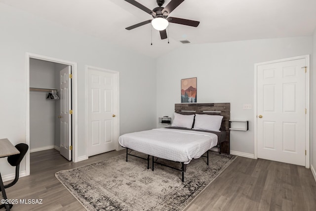 9870 N Meadow Flower Pl, Tucson, AZ 85742 - bedroom with lofted ceiling, wood finished floors, baseboards, a walk in closet, and a closet