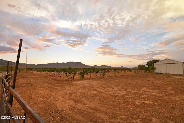 1203 N Cochise Stronghold Rd, Cochise, AZ 85606 - yard at dusk featuring fence, a view of rural / pastoral area, a mountain view, and an outdoor structure
