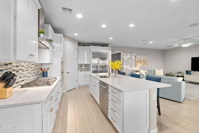 7106 W Foothills Acacia Pl, Marana, AZ 85658 - kitchen featuring stainless steel appliances, a sink, white cabinets, tasteful backsplash, and a ceiling fan