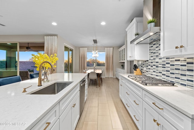 7106 W Foothills Acacia Pl, Marana, AZ 85658 - kitchen featuring wall chimney range hood, a sink, appliances with stainless steel finishes, tasteful backsplash, and white cabinetry