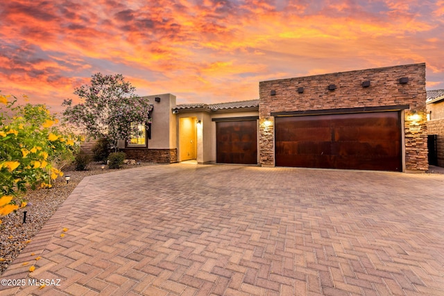 7106 W Foothills Acacia Pl, Marana, AZ 85658 - view of front of home with stone siding, decorative driveway, a garage, and stucco siding