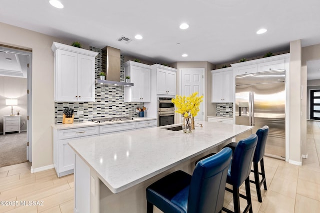 7106 W Foothills Acacia Pl, Marana, AZ 85658 - kitchen with appliances with stainless steel finishes, white cabinetry, a kitchen island with sink, a breakfast bar, and decorative backsplash