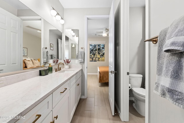 7106 W Foothills Acacia Pl, Marana, AZ 85658 - ensuite bathroom featuring vanity, toilet, ceiling fan, baseboards, and tile patterned floors