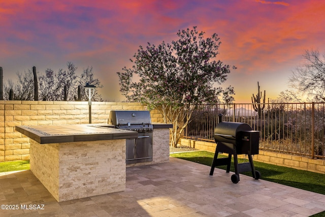 7106 W Foothills Acacia Pl, Marana, AZ 85658 - patio terrace at dusk featuring a patio area and a fenced backyard