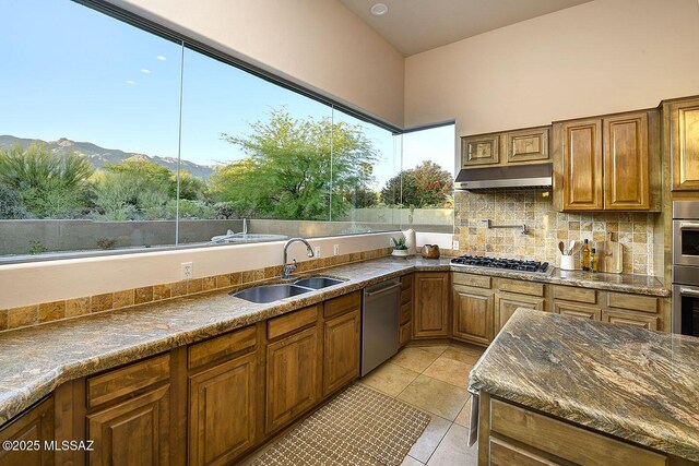 5269 N Pontatoc Rd, Tucson, AZ 85718 - kitchen featuring stainless steel appliances, under cabinet range hood, a sink, light tile patterned flooring, and brown cabinets