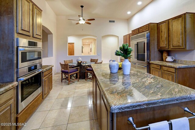 5269 N Pontatoc Rd, Tucson, AZ 85718 - kitchen featuring stainless steel appliances, arched walkways, ceiling fan, light tile patterned floors, and recessed lighting