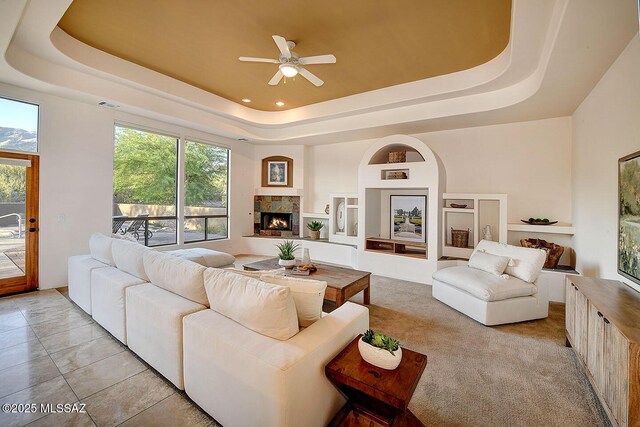 5269 N Pontatoc Rd, Tucson, AZ 85718 - living area with a tray ceiling, a ceiling fan, and a tile fireplace
