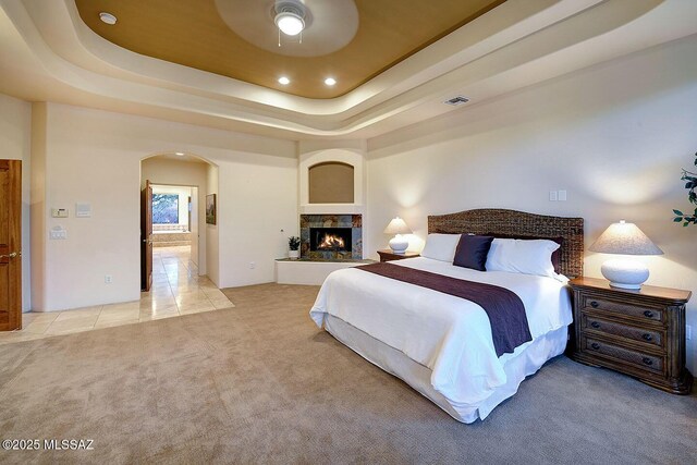 5269 N Pontatoc Rd, Tucson, AZ 85718 - bedroom featuring arched walkways, light colored carpet, recessed lighting, a raised ceiling, and connected bathroom
