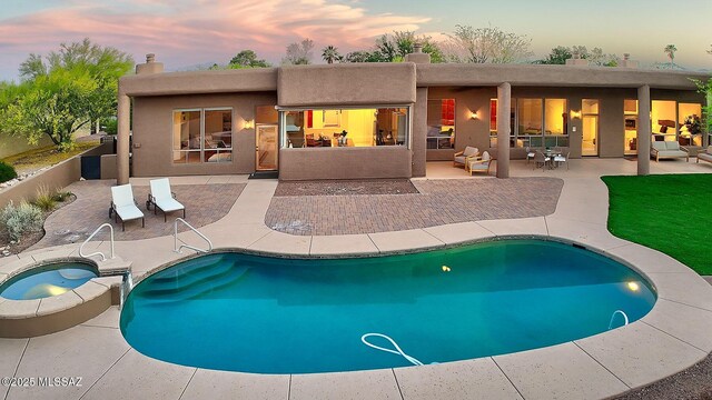 5269 N Pontatoc Rd, Tucson, AZ 85718 - back of property at dusk featuring a patio area, an in-ground hot tub, a chimney, and an outdoor pool