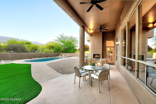 5269 N Pontatoc Rd, Tucson, AZ 85718 - view of patio with ceiling fan, fence, a fireplace, and a mountain view