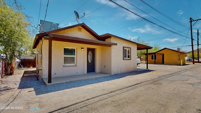 view of front facade with stucco siding and a porch