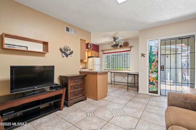 1018 Cll De La Temporada, Green Valley, AZ 85614 - kitchen featuring freestanding refrigerator, a ceiling fan, open floor plan, a textured ceiling, and a peninsula