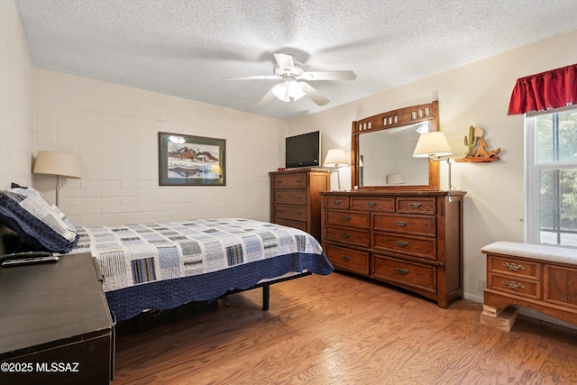 1018 Cll De La Temporada, Green Valley, AZ 85614 - bedroom with light wood-type flooring, a textured ceiling, and ceiling fan