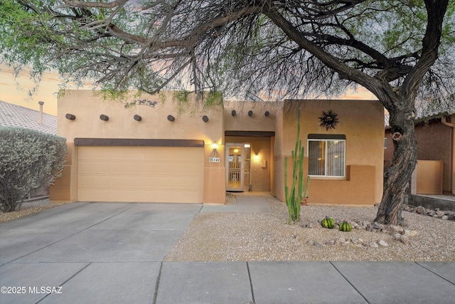 182 N Desert Park Pl, Tucson, AZ 85745 - pueblo-style house featuring stucco siding, concrete driveway, and a garage
