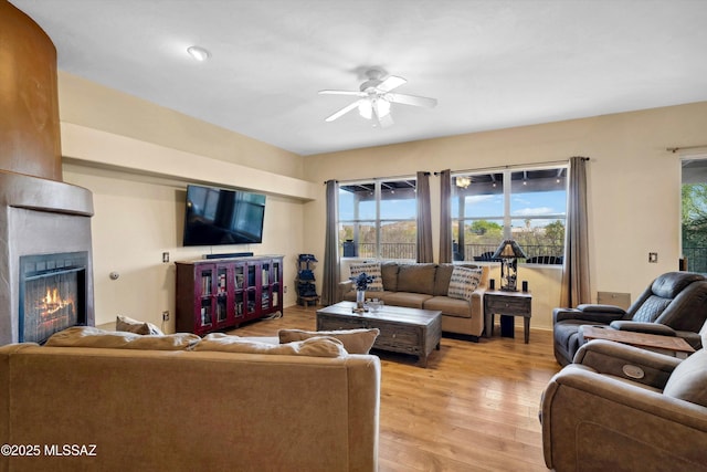 182 N Desert Park Pl, Tucson, AZ 85745 - living area featuring ceiling fan, a fireplace, and light wood-style floors
