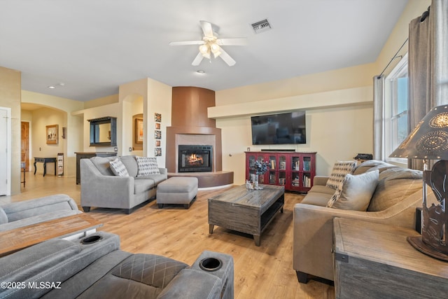 182 N Desert Park Pl, Tucson, AZ 85745 - living area featuring a ceiling fan, arched walkways, light wood-style flooring, and a fireplace