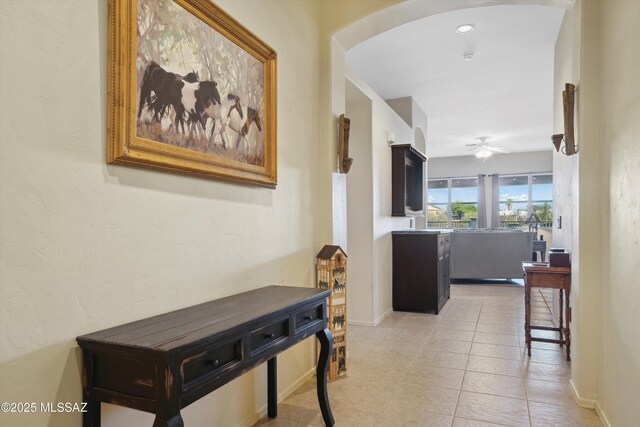 182 N Desert Park Pl, Tucson, AZ 85745 - hall with arched walkways, light tile patterned floors, and baseboards