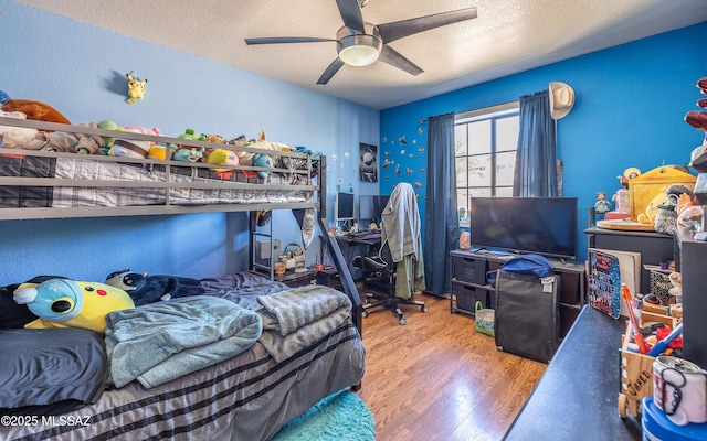 253 Grillo Ct, Rio Rico, AZ 85648 - bedroom with wood finished floors, a textured ceiling, ceiling fan, and a desk