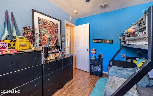 253 Grillo Ct, Rio Rico, AZ 85648 - bedroom with wood finished floors and a textured ceiling