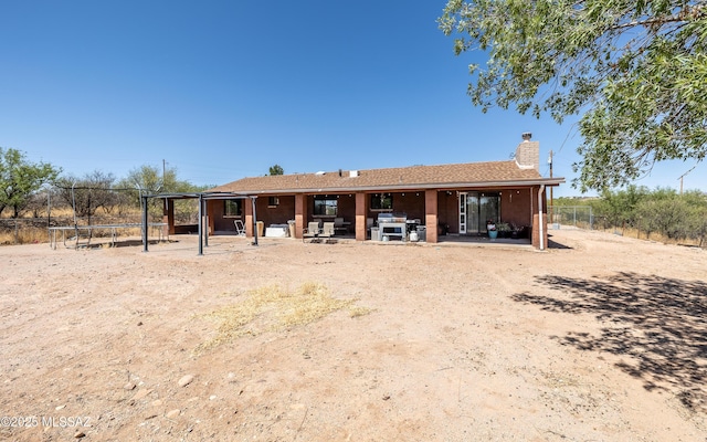 253 Grillo Ct, Rio Rico, AZ 85648 - back of house featuring a trampoline, a patio area, and a chimney