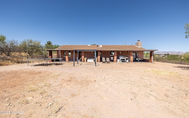 253 Grillo Ct, Rio Rico, AZ 85648 - back of property with a trampoline and a chimney