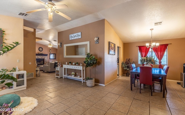 253 Grillo Ct, Rio Rico, AZ 85648 - dining area featuring a ceiling fan, a chandelier, a fireplace, vaulted ceiling, and baseboards