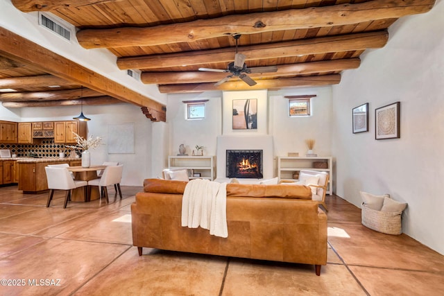 3008 E Placita Santa Lucia, Tucson, AZ 85716 - living area with a wood ceiling with exposed beams, a warm lit fireplace, and ceiling fan