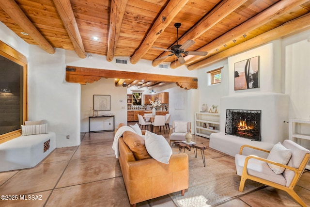 3008 E Placita Santa Lucia, Tucson, AZ 85716 - living area featuring a wooden ceiling with exposed beams, a ceiling fan, a lit fireplace, recessed lighting, and concrete flooring