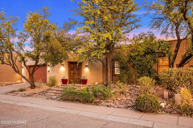 3008 E Placita Santa Lucia, Tucson, AZ 85716 - view of property hidden behind natural elements featuring concrete driveway, an attached garage, and stucco siding