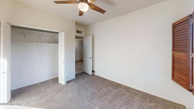 unfurnished bedroom with carpet, a closet, and ceiling fan