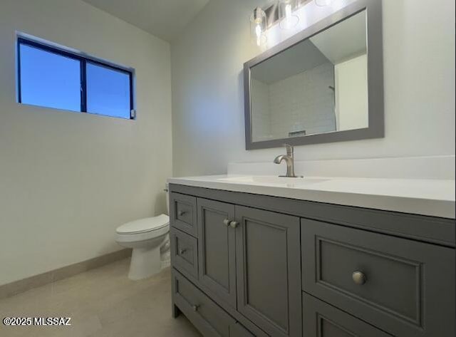 bathroom featuring vanity, baseboards, and toilet
