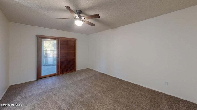 carpeted empty room featuring ceiling fan and a textured ceiling