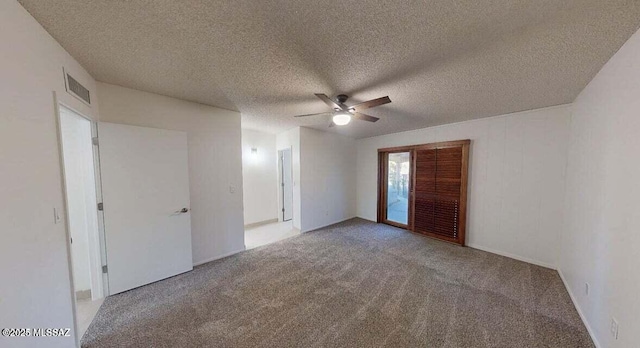 empty room with a ceiling fan, carpet floors, and a textured ceiling