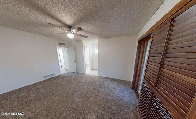 carpeted spare room with a ceiling fan and a textured ceiling