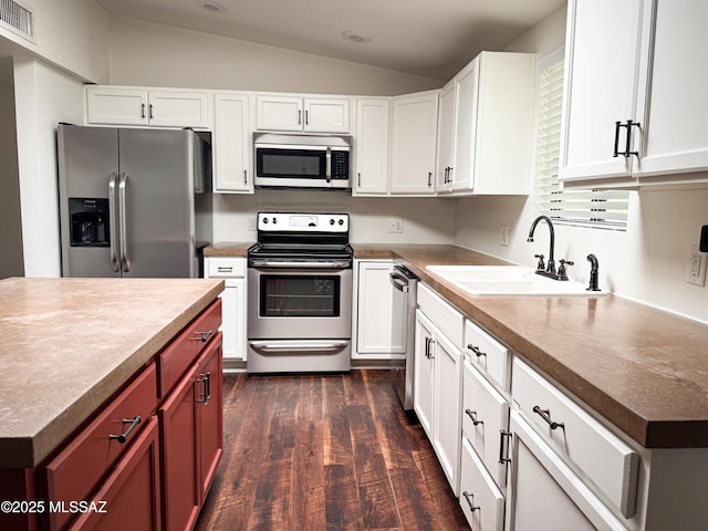 3700 S Serena Ln, Tucson, AZ 85730 - kitchen featuring stainless steel appliances, vaulted ceiling, a sink, dark wood-style floors, and white cabinetry