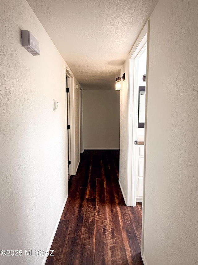 3700 S Serena Ln, Tucson, AZ 85730 - corridor with wood finished floors, a textured wall, a textured ceiling, and baseboards