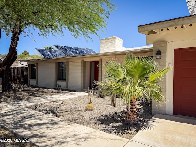 3700 S Serena Ln, Tucson, AZ 85730 - view of front of house with a garage, a chimney, solar panels, and brick siding