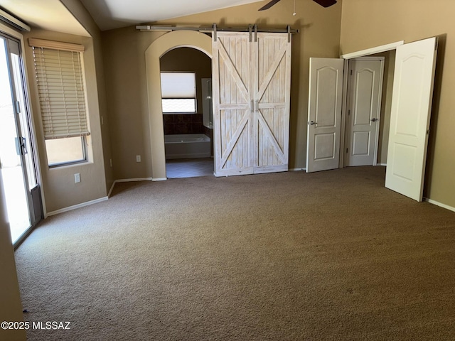 262 W Calle Paso Suave, Sahuarita, AZ 85629 - spare room featuring a ceiling fan, carpet flooring, baseboards, arched walkways, and a barn door