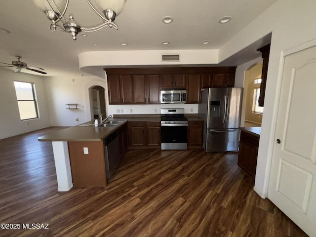262 W Calle Paso Suave, Sahuarita, AZ 85629 - kitchen featuring appliances with stainless steel finishes, arched walkways, dark wood-style floors, a sink, and recessed lighting