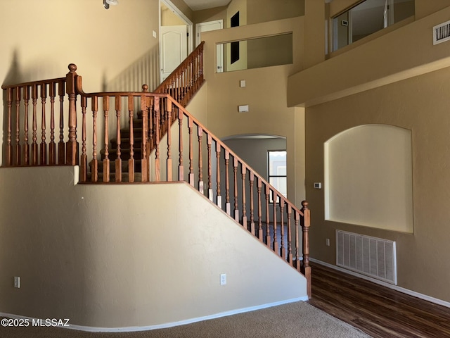 262 W Calle Paso Suave, Sahuarita, AZ 85629 - stairway featuring arched walkways, baseboards, wood finished floors, and a towering ceiling