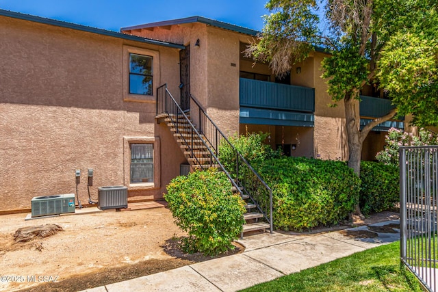 view of property with stairway and cooling unit