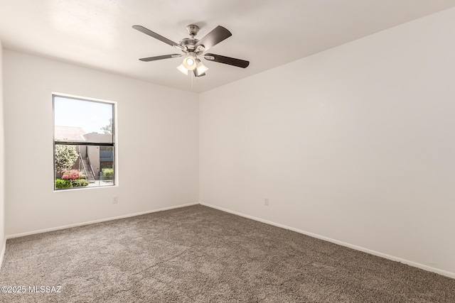 empty room featuring carpet, baseboards, and ceiling fan