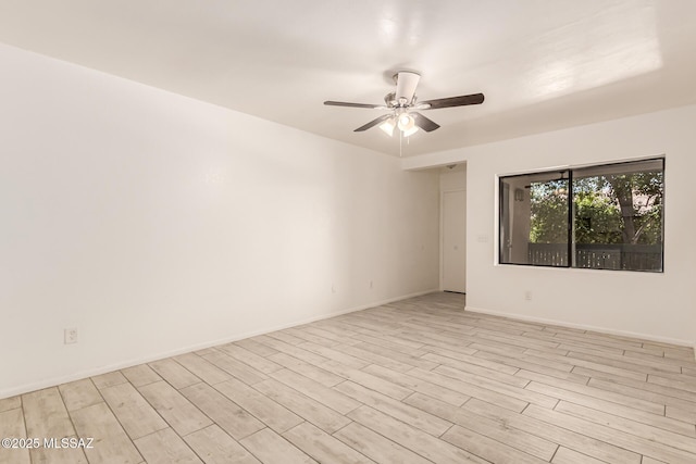 unfurnished room with a ceiling fan, light wood-type flooring, and baseboards