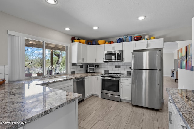2282 W Rapallo Way, Tucson, AZ 85741 - kitchen featuring stainless steel appliances, a sink, white cabinets, light stone countertops, and recessed lighting